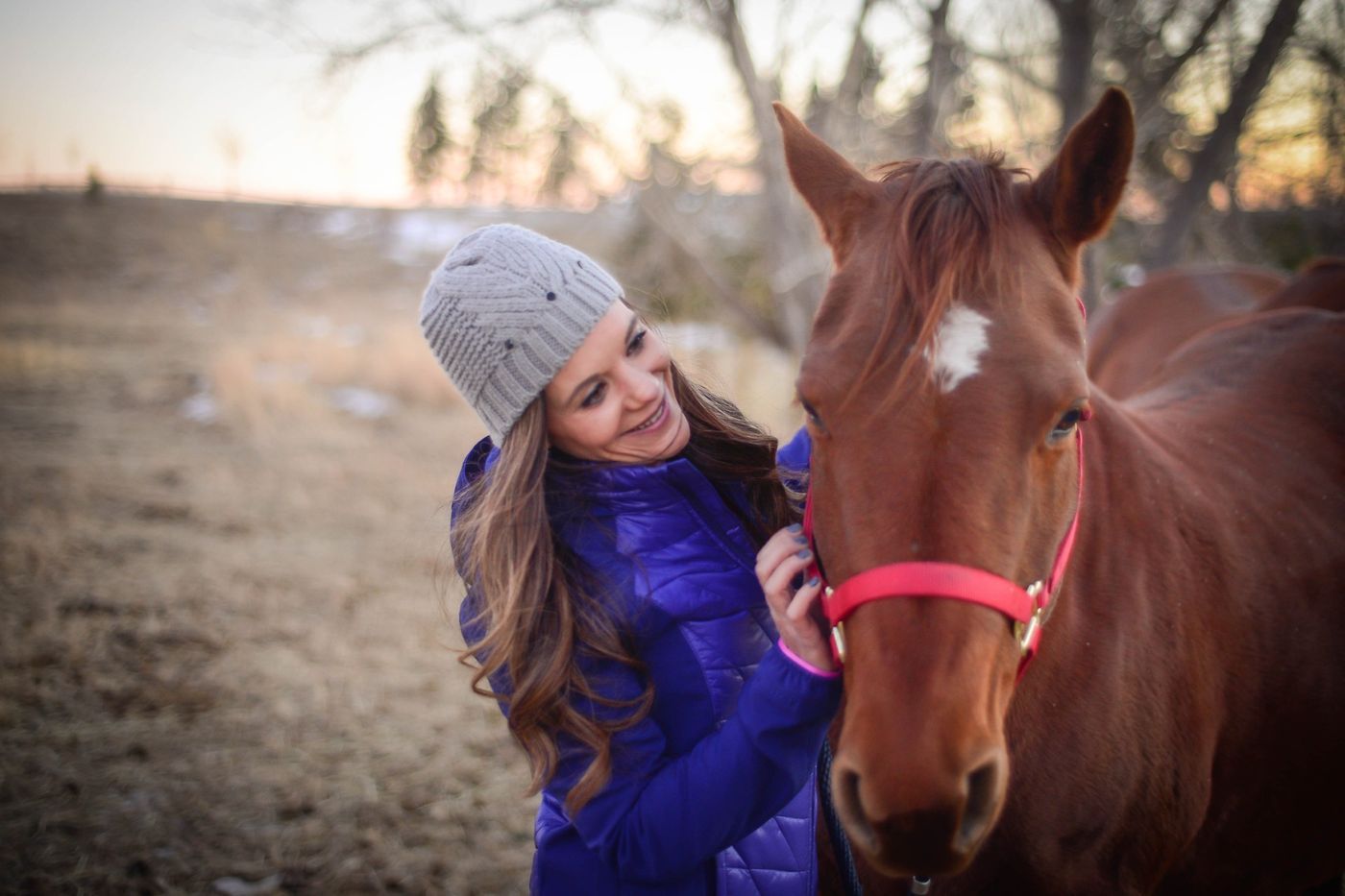 Michelle with her chestnut horse in a red halter